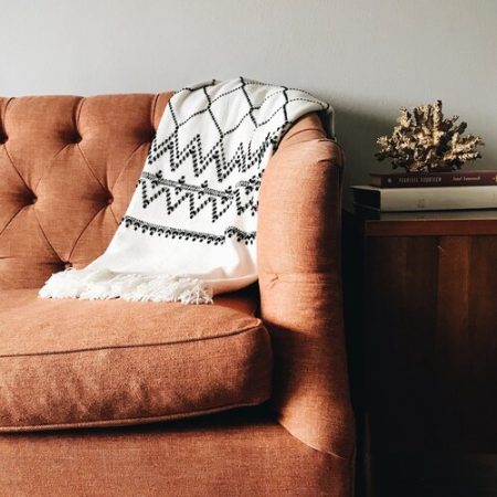 close up of a brown couch and throw blanket