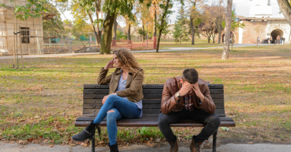 Man and woman having tension conflict on a park bench