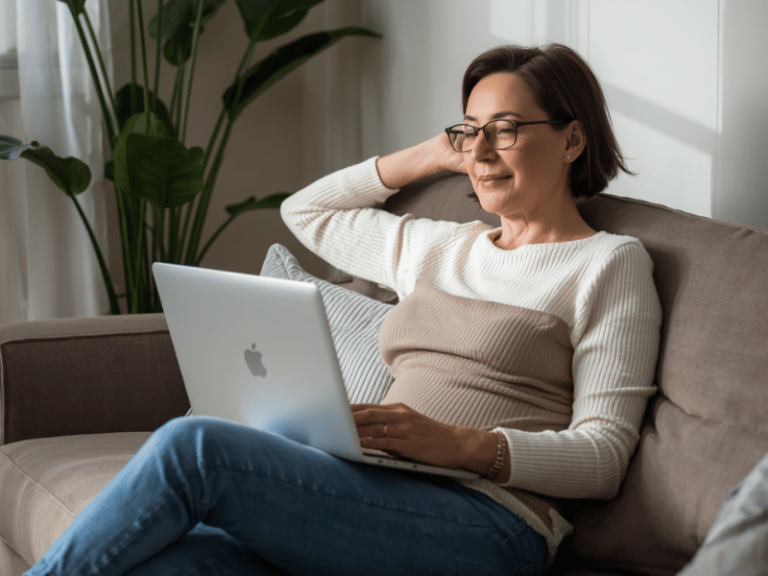 Middle aged woman relaxing during an online therapy session on her couch